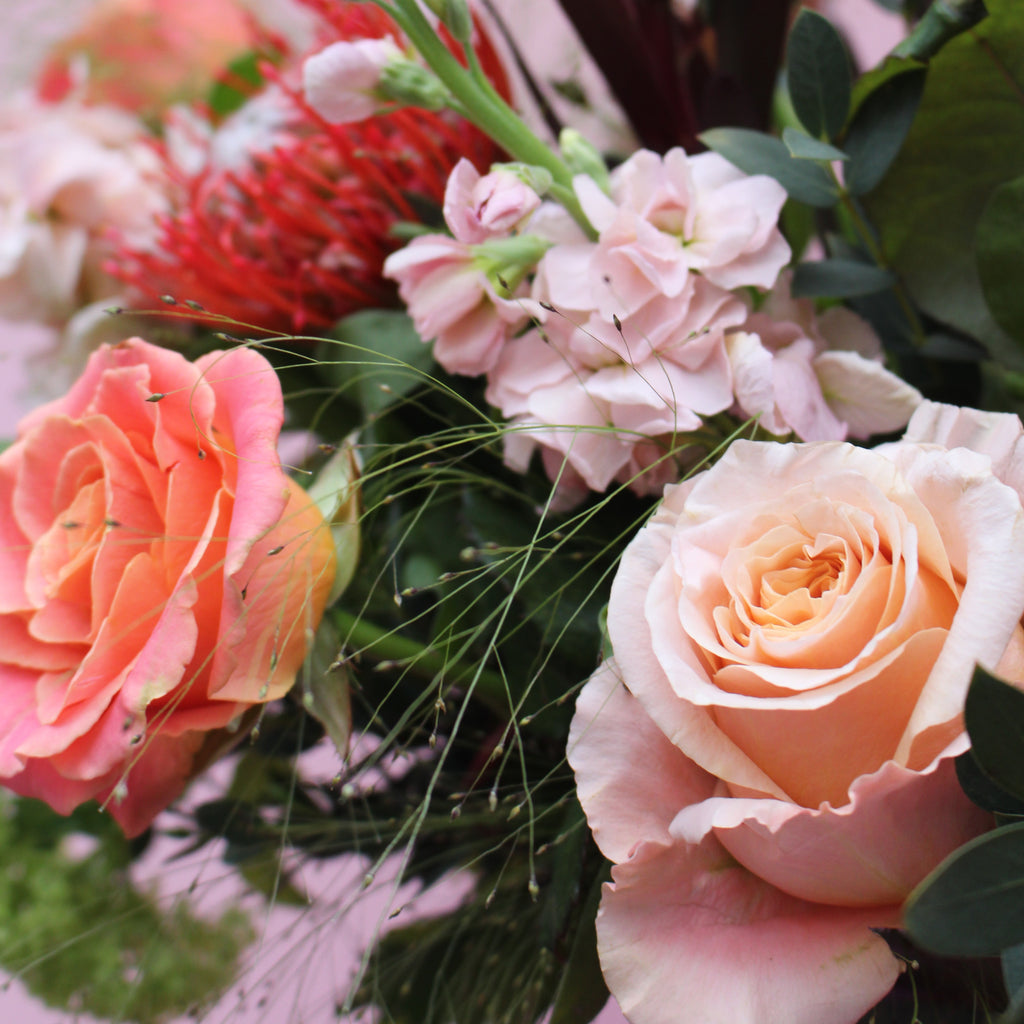 Notting Hill (Cosy winter vibes with this bouquet in reds, peaches, lime green and coral including mixed roses, stocks, pin cushions and viburnum)