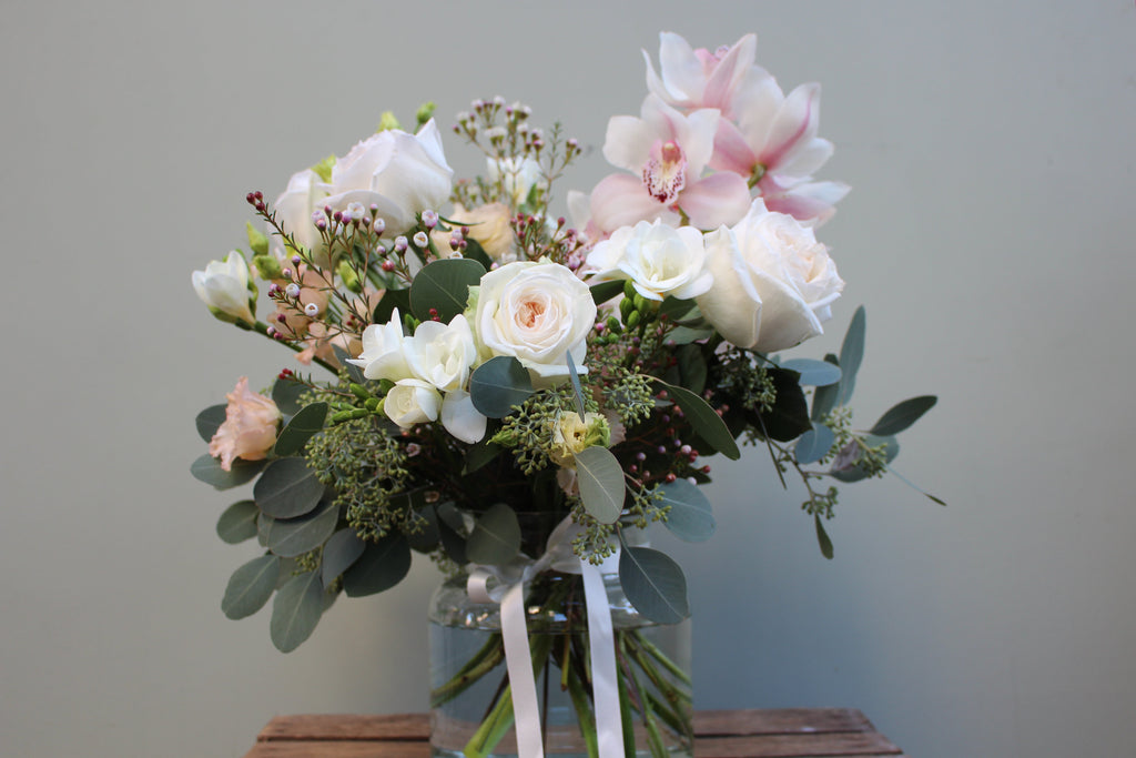 Breakfast at Tiffany's (A classic combination of O'Hara roses, freesia, lisianthus, waxflower and cymbidium orchid in whites and pale pinks)