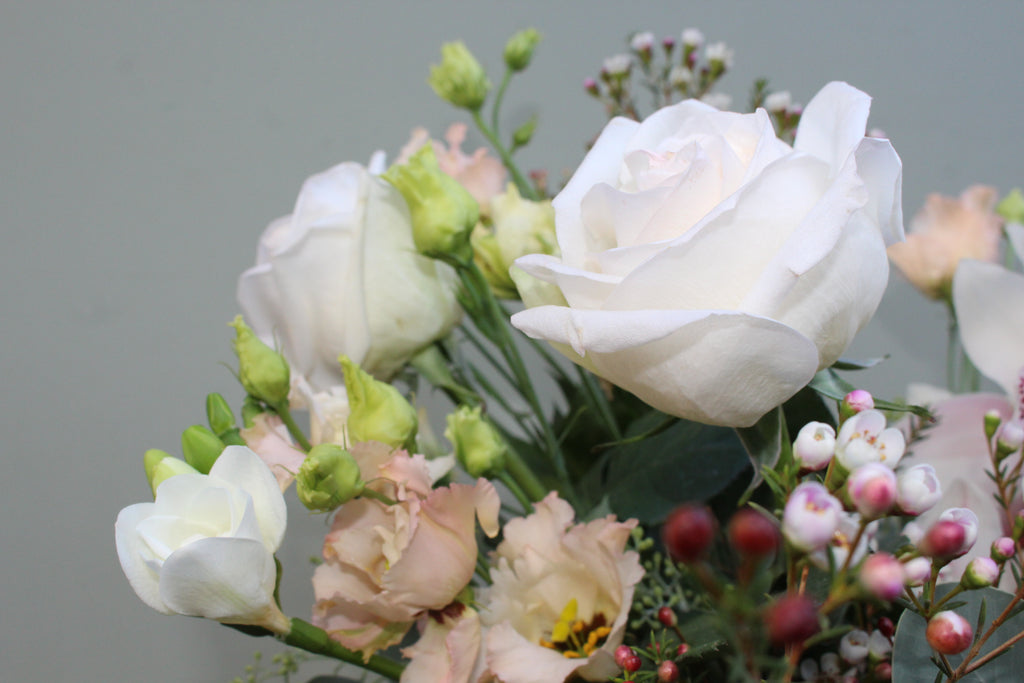 Breakfast at Tiffany's (A classic combination of O'Hara roses, freesia, lisianthus, waxflower and cymbidium orchid in whites and pale pinks)