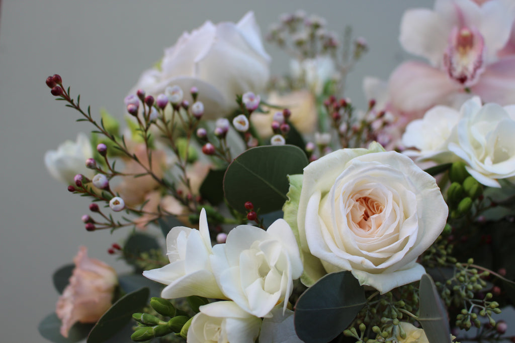 Breakfast at Tiffany's (A classic combination of O'Hara roses, freesia, lisianthus, waxflower and cymbidium orchid in whites and pale pinks)