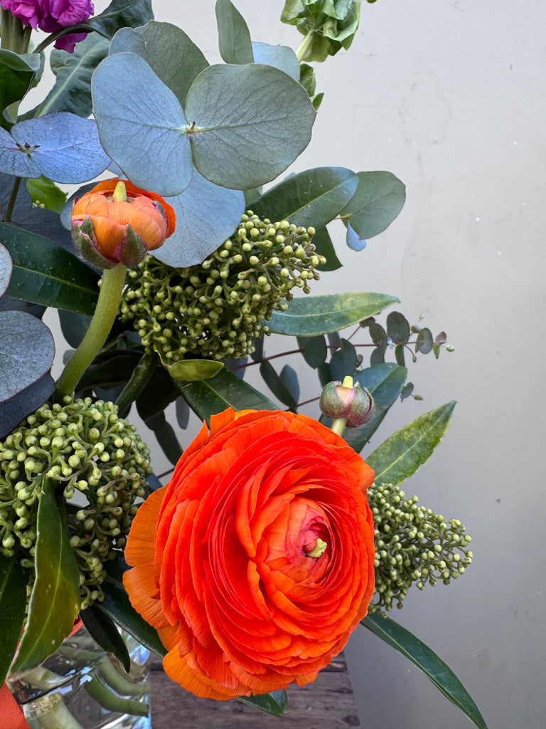 Lorelai (A juicy, bright creation containing ranunculus, skimmia, viburnum, hydrangea, stocks and mollucella in cerise pink, lime green and orange.)